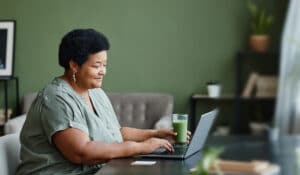 Woman working on her laptop with a smile on her face
